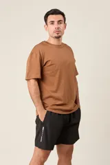 Bermuda deportiva gris oscuro de nylon, de corte suelto, con cintura elástica y cordón de ajuste. Cuenta con detalles de líneas en los costados y bolsillos con cierre.