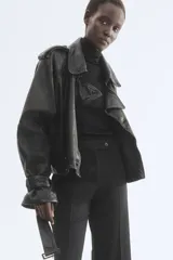 Pantalón tobillero negro de corte bootcut, con raya marcada adelante y atrás. Cuenta con cintura estándar con elástico oculto, cierre con pretina prolongada y botones, bolsillos al bies y bolsillo trasero ribeteado.