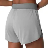 Short deportivo Fila de doble capa para mujer, en color gris. Cuenta con una capa exterior ligera y holgada, y una capa interior ajustada de tipo calza corta, con cintura elástica ancha y logo de la marca estampado en el lateral.