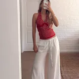 Top halter rojo con escote en V y apliques metálicos plateados.