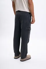 Pantalon de jean en color negro con efecto lavado, corte cargo con bolsillos laterales y diseño de costuras reforzadas en las rodillas.