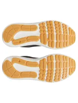 Championes de running Under Armour modelo Charged Versurge, color negro con suela blanca y base de goma color caramelo. Presentan una parte superior de malla con revestimientos de gamuza sintética y logo de la marca en el talón.