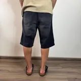 Bermuda de jean de corte ancho y largo, color negro lavado, con tiro medio y bolsillos delanteros y traseros.