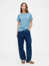 Remera azul de manga corta con cuello redondo y un pequeño oso bordado en el pecho.