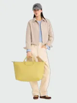 Bolso de viaje grande Longchamp modelo Le Pliage One, color amarillo verdoso, con doble asa corta y solapa frontal con cierre de broche a presión y botón de presión.