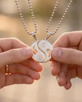 Dije de acero inoxidable con diseño de Yin-Yang, compuesto por dos piezas complementarias que forman un círculo completo, cada una con un símbolo de Yin-Yang grabado.