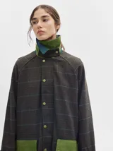 Trench oversize de lana a cuadros con cuello, puños y bolsillos de pana verde.