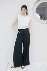 Pantalón de lino de pierna amplia y corte recto, color beige, con trabillas para cinto y cierre frontal con botón.