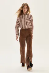 Camisa de manga larga con cuello y puños, confeccionada en tejido de rayas verticales en tonos crema y bordó. Presenta un bolsillo de parche en el pecho con un bordado exclusivo.