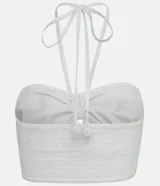 Blusa corta blanca de algodón con bordado de palmeras color naranja, escote halter y espalda descubierta.