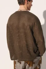 Camiseta de punto con estructura abierta tipo crochet, de corte relajado, cuello panadero con cierre frontal de botones y manga larga.