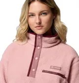 Buzo de polar tipo sherpa color rosado, con cuello alto y cierre frontal parcial con botones a presión. Presenta un bolsillo con cierre en el pecho y detalles de ribete en color bordó.