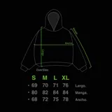 Hoodie oversize de color blanco con estampado artístico en tonos marrones y dorados en el pecho y las mangas. Presenta un forro interior de capucha en tejido marrón texturizado y costuras reforzadas.