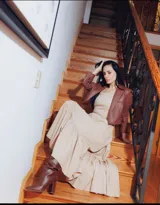 Vestido largo color beige con corte a la cintura, falda amplia con volados y breteles finos.