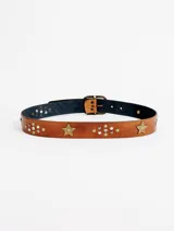 Cinto de cuero marrón con hebilla metálica de acabado envejecido, decorado con apliques de estrella, tachas metálicas redondas y detalles de piedras brillantes.