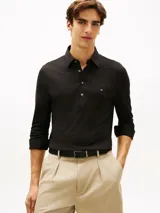Chomba de manga larga de Tommy Hilfiger en color negro, confeccionada en mezcla de algodón y modal con tejido interlock ligero. Cuenta con cuello clásico, cartera de cuatro botones y el logo bordado en el pecho.