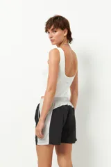 Short deportivo negro con detalles en verde militar, cintura elastizada, bolsillos laterales y ribete blanco.