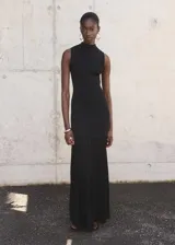 Vestido largo de diseño combinado con cuerpo entallado de tejido de punto fino y falda evasé. Presenta cuello perkins, diseño sin mangas y cierre de cremallera en la parte posterior.