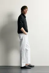 Jeans regular fit de corte recto y tiro medio, confeccionados en denim de algodón blanco con diseño de cinco bolsillos y cierre frontal con cremallera y botón.