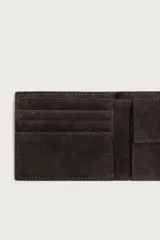 Billetera de piel con acabado en serraje color marrón oscuro, de diseño compacto con detalle de costura horizontal en el centro. Cuenta con compartimento para billetes, ranuras para tarjetas y monedero con cierre de clip.
