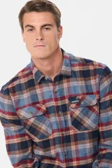 Sobrecamisa de viyela gruesa con estampado de cuadros en tonos azul, rojo y marrón. Presenta cuello clásico, cierre frontal con botones y dos bolsillos delanteros con solapa y botón.