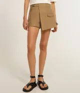 Bermuda de sastrería color tostado, con diseño traslapado, hebilla en la cintura y bolsillos frontales con solapa.