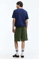 Bermuda cargo verde militar de ripstop de algodón, con bolsillos laterales con solapa, bolsillos al bies y corte holgado.