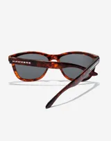 Lentes de sol Hawkers modelo One con armazón de acetato en estampado carey y cristales polarizados oscuros.