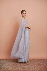 Vestido largo de encaje color plata con brillos y cuello halter. Incluye capa de gasa larga.