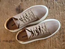 Zapatillas urbanas de cuero color marrón con textura granulada, cordones al tono y suela de plataforma dentada en color blanco.