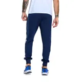 Pantalón de jogging azul marino con cintura elástica ajustable con cordón, bolsillos laterales con cierre y puños elásticos. Logo de Umbro y escudo del Club Nacional de Football estampados en el frente.