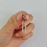 Aros colgantes plateados con forma de barra vertical con incrustaciones de circonitas.