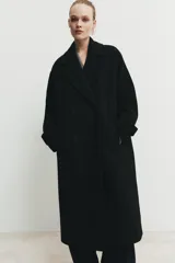 Abrigo largo de corte oversize con cuello de solapa, manga larga y cierre frontal cruzado con botones. Cuenta con bolsillos delanteros.