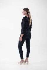 Mono largo negro con lentejuelas, escote en V cruzado, mangas largas y corte ajustado.