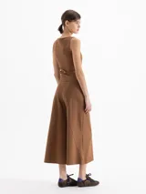 Pantalon de corte amplio y estilo culotte, confeccionado en tejido de punto color negro. Presenta cintura elastizada, cierre lateral y detalles de costuras verticales con pespuntes decorativos que recorren el frente de las piernas.