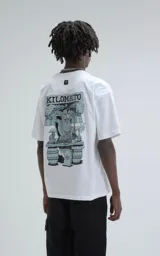 Remera blanca de corte oversize y hombros caídos, confeccionada en algodón premium. Presenta cuello redondo acanalado y estampado frontal con las siglas KM y el hashtag #KILOMBITOMAL en color negro.