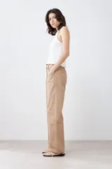 Pantalón de gabardina color tostado, de corte recto, con bolsillos laterales y traseros. Se ajusta a la cintura con cinturón de cuero con estampado animal print.
