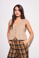 Chaleco de punto sin mangas, color camel jaspeado, con escote en V y cierre frontal de tres botones marrones.