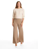 Pantalón de tiro alto con corte wide leg, confeccionado en tejido elastizado. Presenta una costura vertical decorativa en el frente de cada pierna y un diseño de calce cómodo.