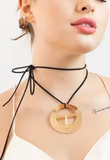 Gargantilla choker negra con dije circular dorado.