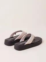 Sandalias de dedo color crudo con plataforma baja color negro.