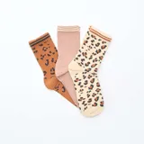 Pack de tres pares de medias de caña media. Un par color marrón con estampado de leopardo negro, un par color rosa liso con dos rayas horizontales en la parte superior y un par color crema con estampado de leopardo marrón.