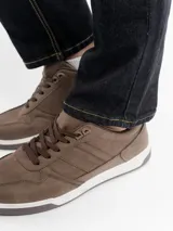 Zapato urbano de estilo casual, color marrón con acabado mate, cordones al tono y suela de goma blanca con base gris. Presenta costuras decorativas en los laterales.