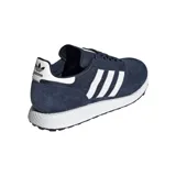 Championes Adidas modelo Forest Grove, color azul marino con las icónicas tres tiras laterales en blanco. Presentan una combinación de gamuza y malla en el exterior, con una entresuela blanca texturizada y suela de goma negra.