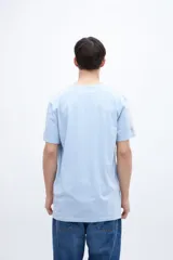 Remera celeste de algodón con bolsillo en el pecho, arte en el bolsillo y bordado en la manga.