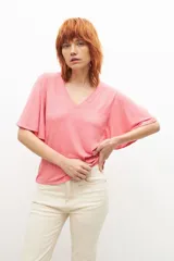 Remera fucsia de canalé con escote en V y mangas cortas con volados.
