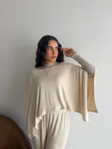 Conjunto de dos piezas de lanilla en color gris melange, compuesto por una blusa de corte amplio con mangas murciélago y escote bote, y un pantalón recto con bolsillos laterales.