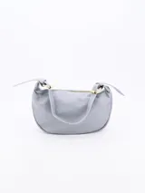 Cartera de hombro tipo baguette color gris claro, con acabado ligeramente arrugado o satinado y correa corta ajustable con herrajes dorados.