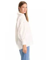 Camisa blanca de la marca Liv Los Ángeles, con cuello con solapa y cierre frontal de botones. Presenta mangas largas con detalles calados y puños anchos con botones.