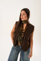 Chaleco marrón de gamuza con cordones laterales y tachas plateadas.